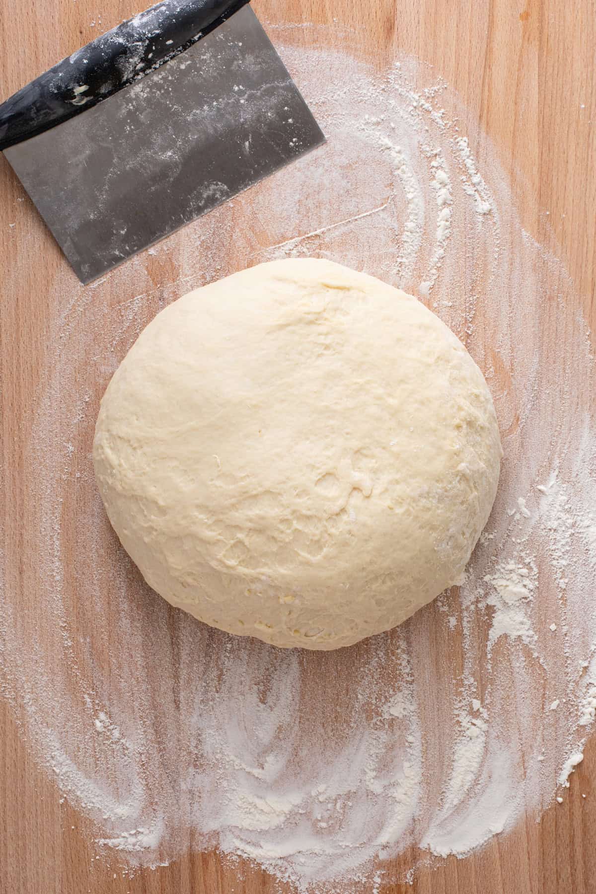 Kneaded brown and serve roll dough on a wooden board.