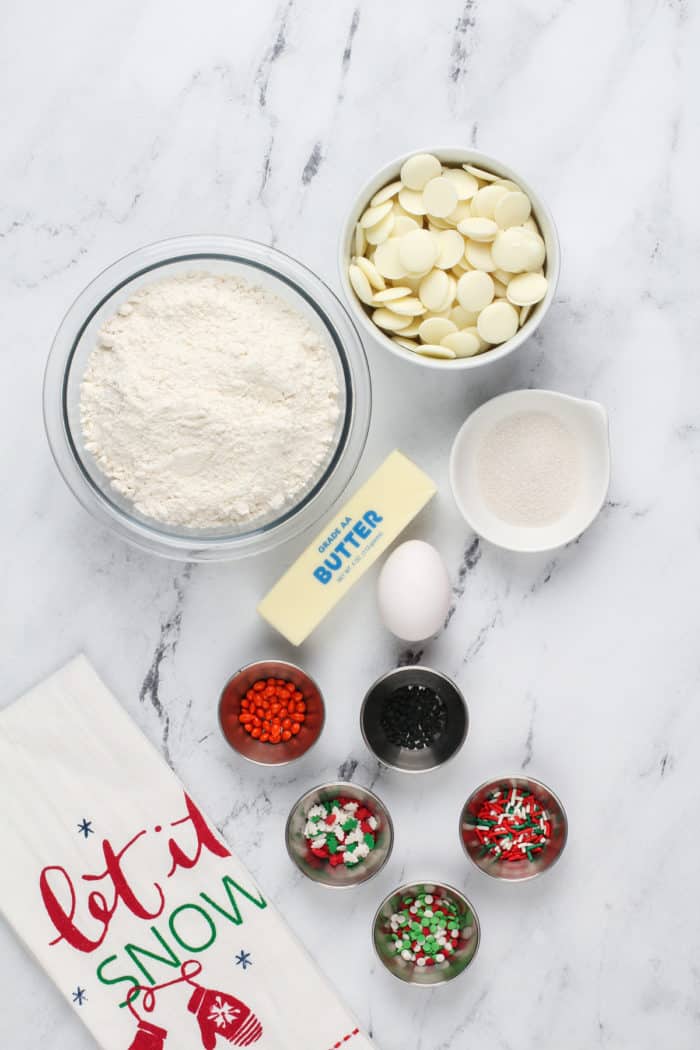 Melted snowman cookie ingredients arranged on a marble countertop.