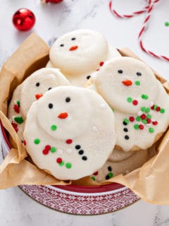 Festive holiday tin filled with melted snowman cookies.