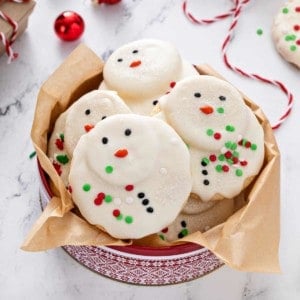 Festive holiday tin filled with melted snowman cookies.