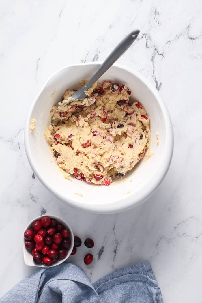 Orange cranberry cookie dough in a white mixing bowl