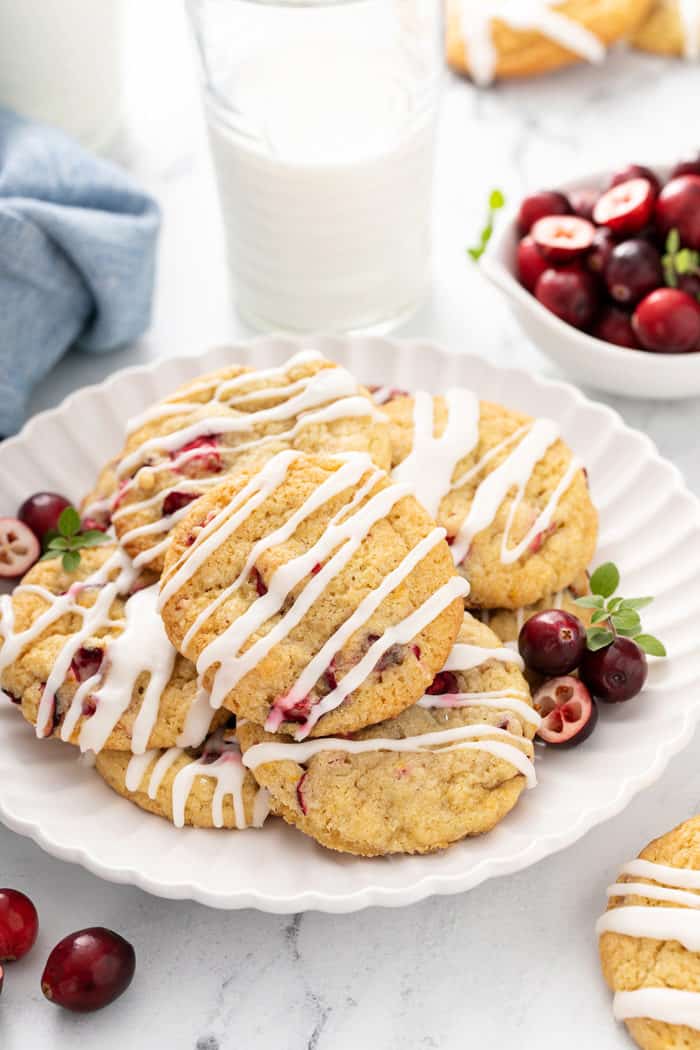 White plate piled high with orange cranberry cookies