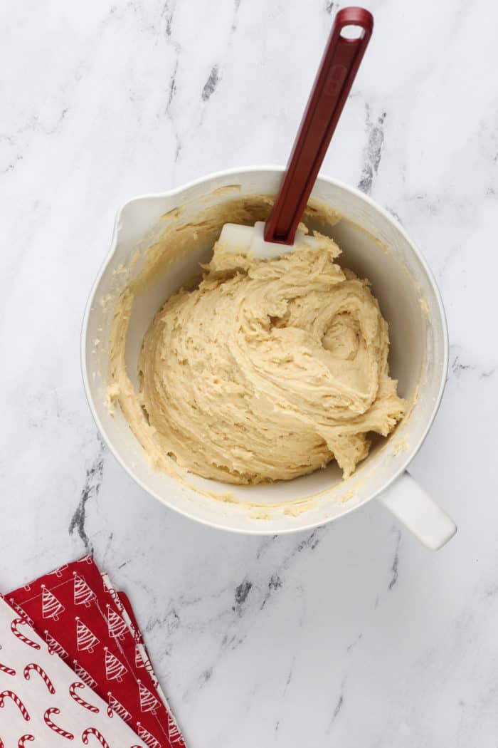 Dough for sour cream cookies mixed together in a white bowl.