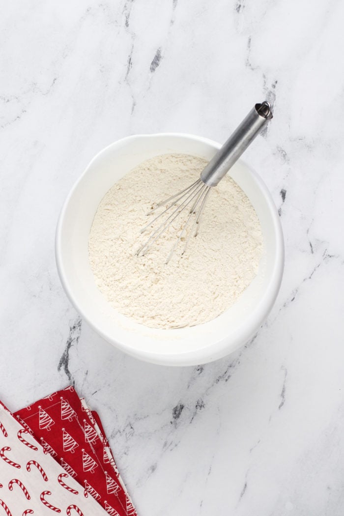 Dry ingredients for sour cream cookies whisked together in a white bowl.