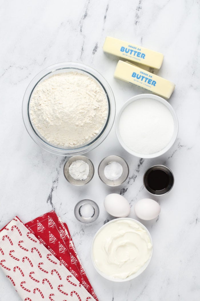 Ingredients for sour cream sugar cookies on a marble countertop.