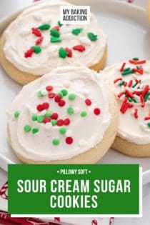 Three sour cream sugar cookies, topped with Christmas sprinkles, on a white plate. Text overlay includes recipe name.