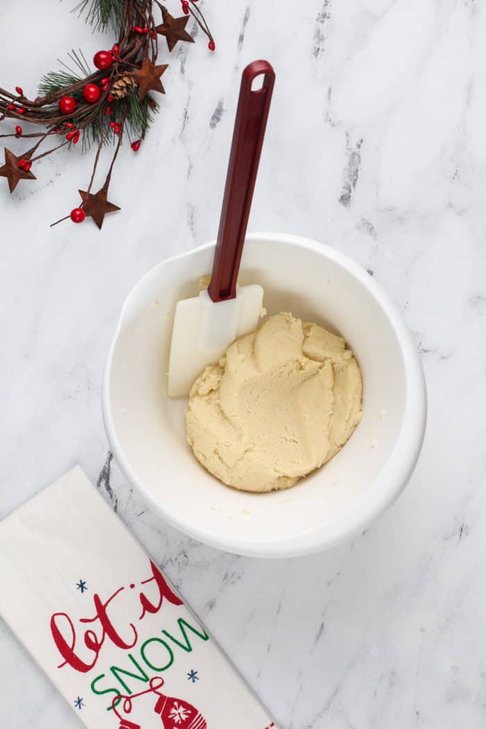 Sugar cookie dough in a white bowl.