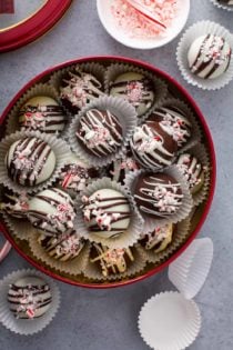 Cookie tin filled with Peppermint oreo balls on a gray counter