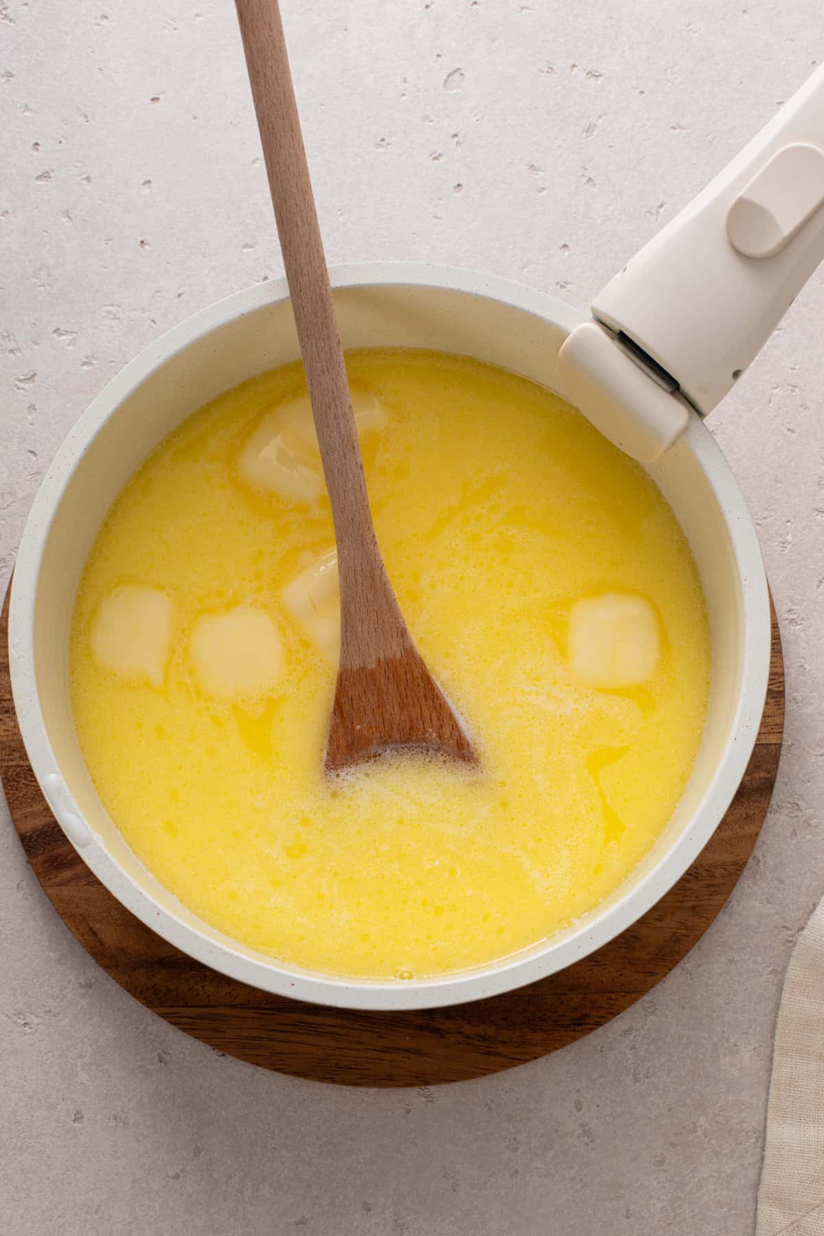 Wet ingredients for brown and serve rolls warmed in a saucepan.