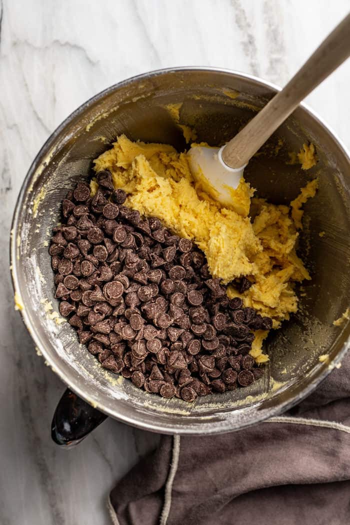 Spatula folding chocolate chips into pudding cookie dough