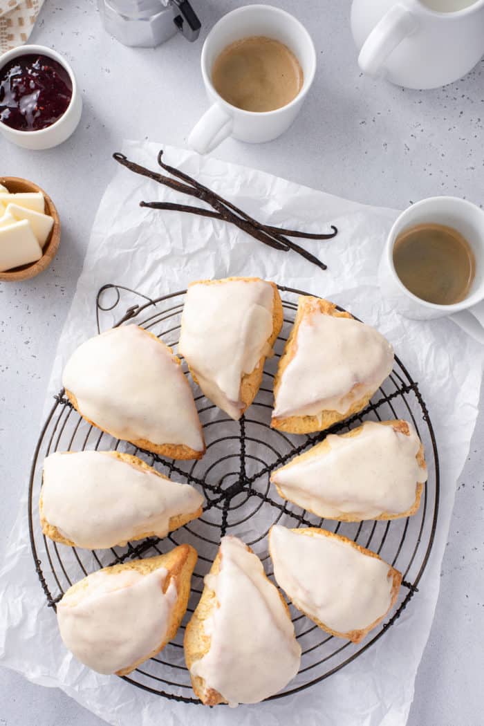 Overhead view of 8 vanilla bean scones arranged on a wire cooling rack.