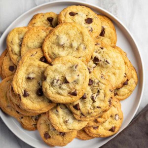 White platter filled with chocolate chip pudding cookies, set on a marble countertop