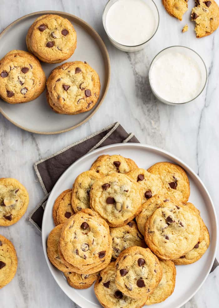 Plates filled with chocolate chip pudding cookies next to glasses of milk