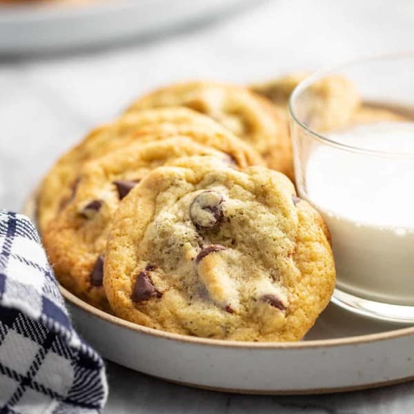 Chocolate Chip Pudding Cookies arranged on a plate around a glass of milk