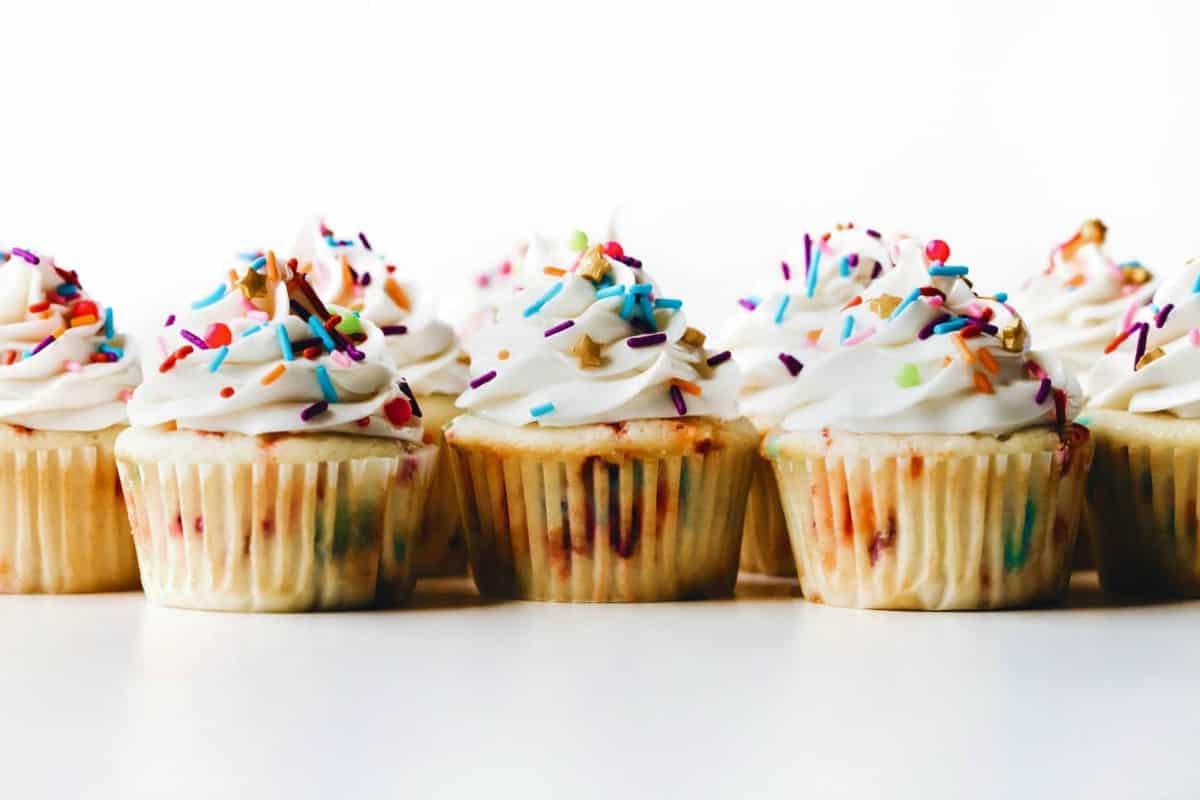 Baked and decorated funfetti cupcakes lined up, ready to serve