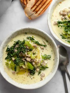 Zuppa toscana in white bowls next to grilled bread