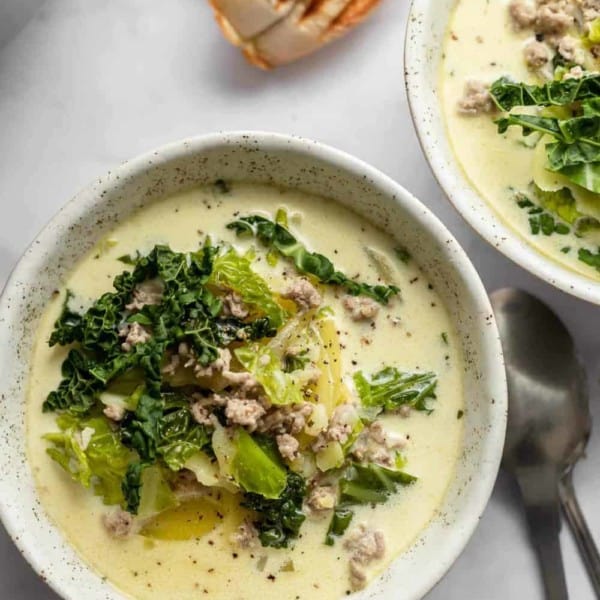 Zuppa toscana in white bowls next to grilled bread