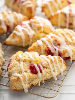 Close up of glazed lemon raspberry scones on a wire cooling rack