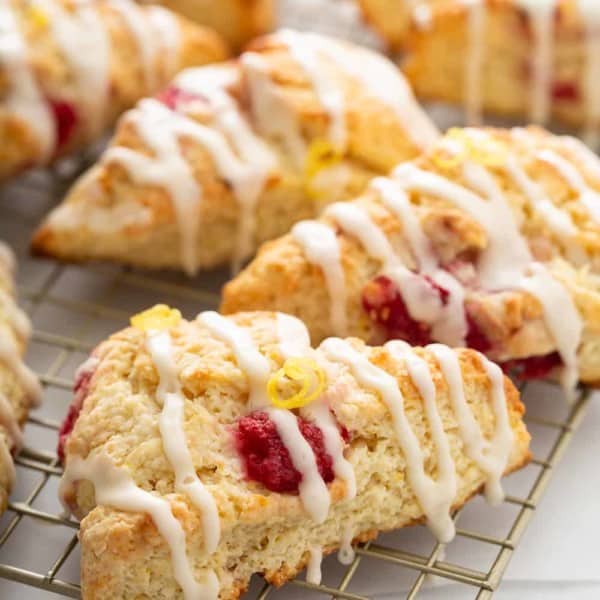 Close up of glazed lemon raspberry scones on a wire cooling rack