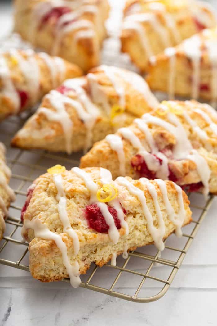 Close up of glazed lemon raspberry scones on a wire cooling rack