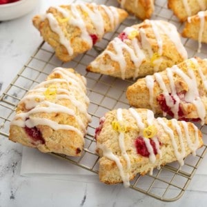 Lemon raspberry scones arranged on a wire cooling rack on a marble countertop