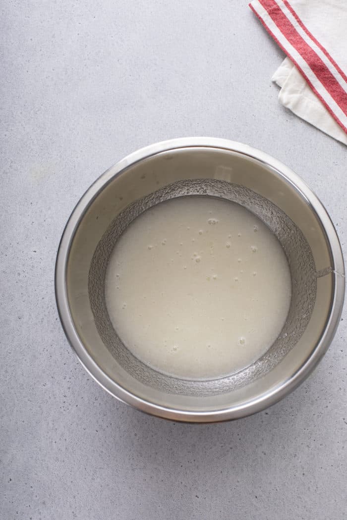 Ingredients for marshmallow frosting mixed in a metal bowl, ready to be cooked.