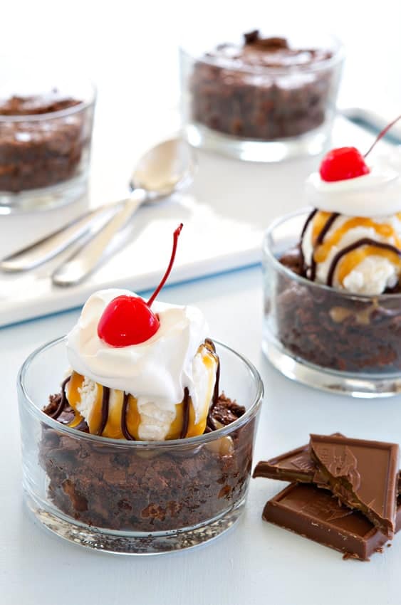 Ghirardelli Stuffed Brownies are topped with vanilla bean ice cream, and caramel sauce to create an indulgent sundae.