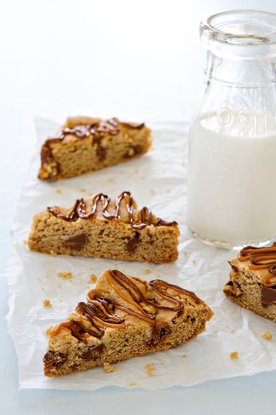 Snickers Chocolate Chip Cookie Bars bake up in 30 minutes! Drizzle them with caramel and chocolate to make them even more irresistible.
