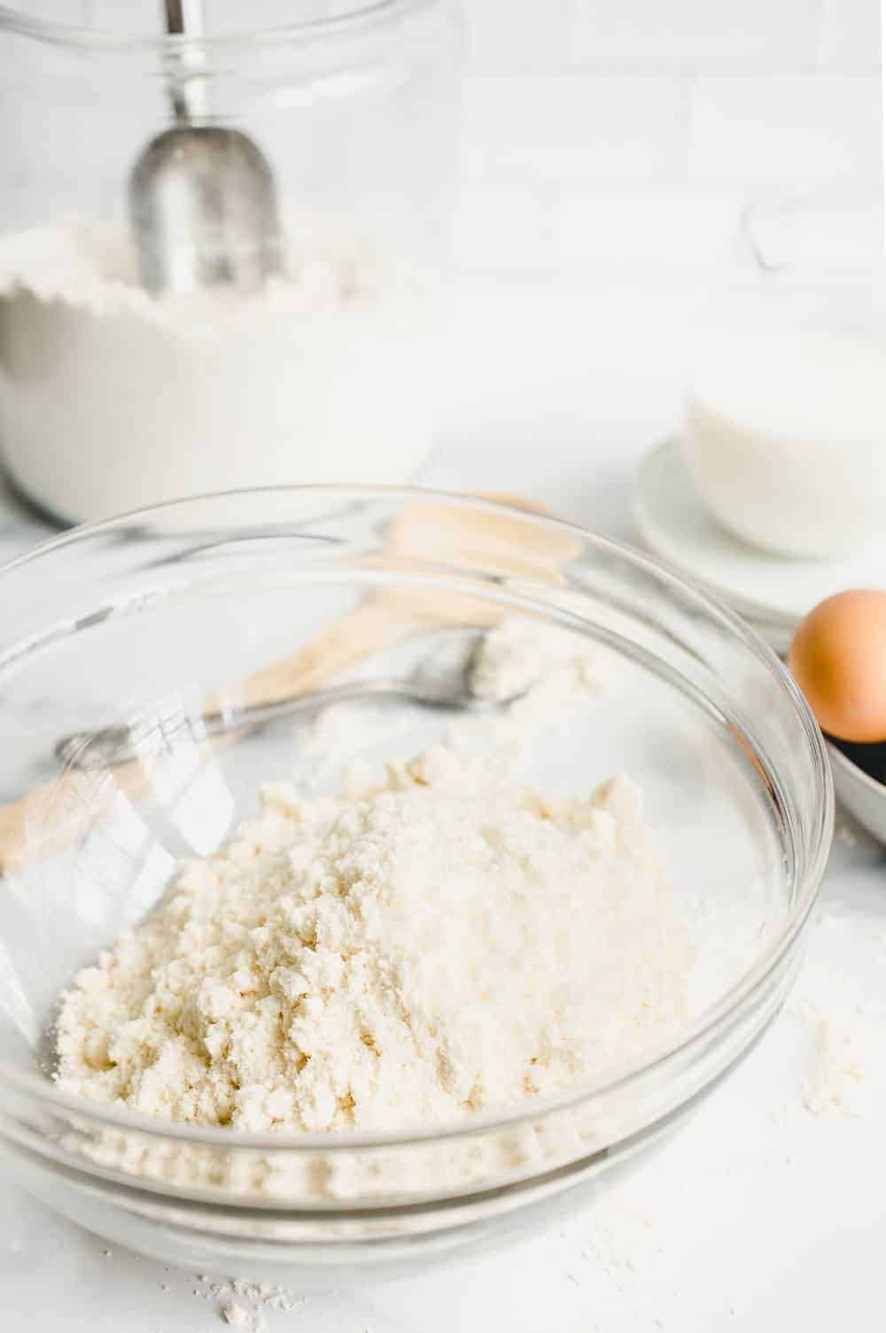 Homemade Bisquick mix in a glass mixing bowl on a marble surface