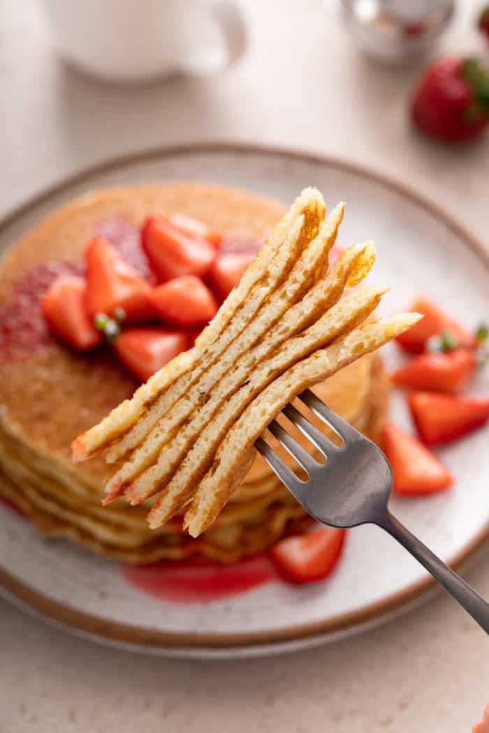 Fork holding up a bite of gluten-free pancakes.