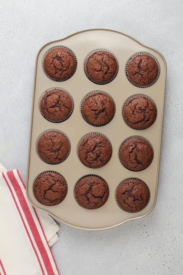 Baked chocolate cupcakes for s'mores cupcakes cooling in the cupcake pan.