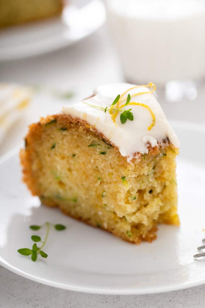 Slice of lemon zucchini cake with a bite taken from the end of it.