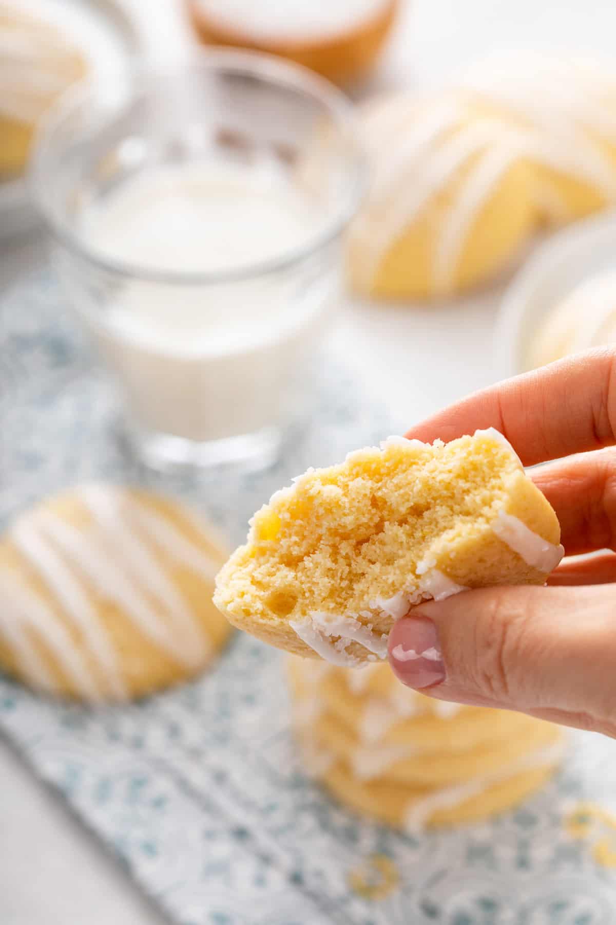 Hand holding up a pound cake cookie that is broken in half to show the inner texture.