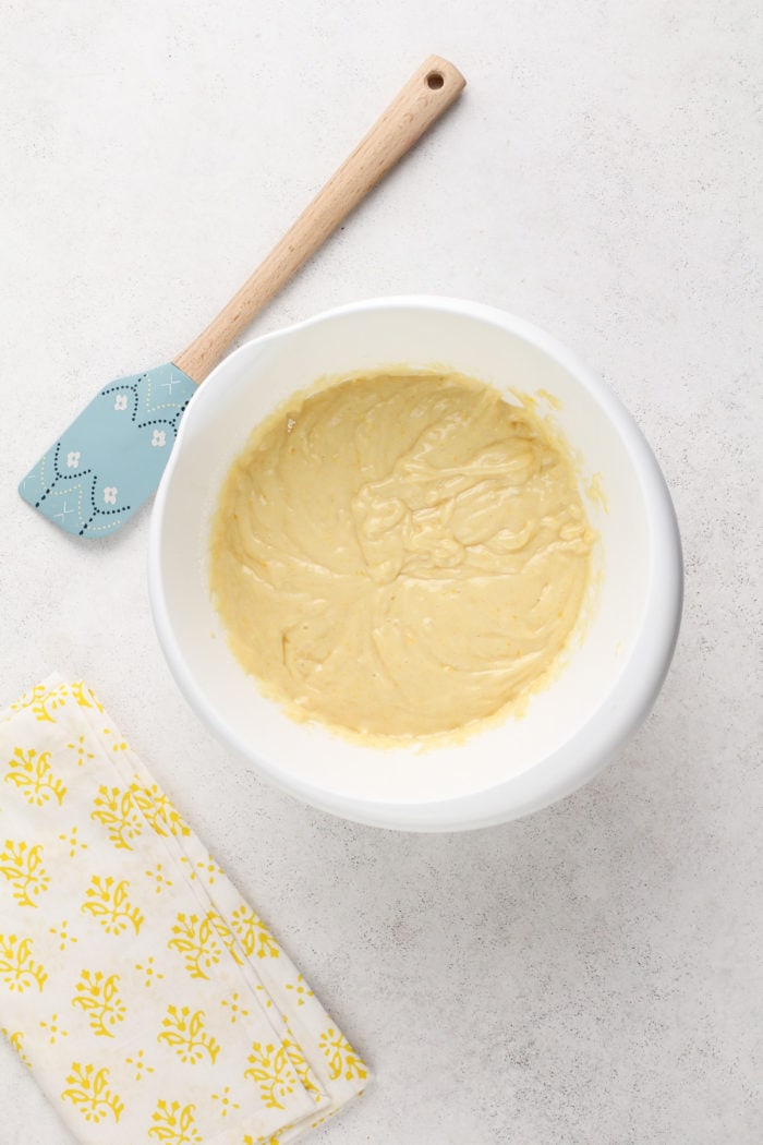 Batter base for lemon zucchini cake in a white mixing bowl.