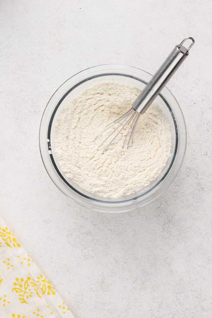 Dry ingredients for lemon zucchini cake in a glass mixing bowl.