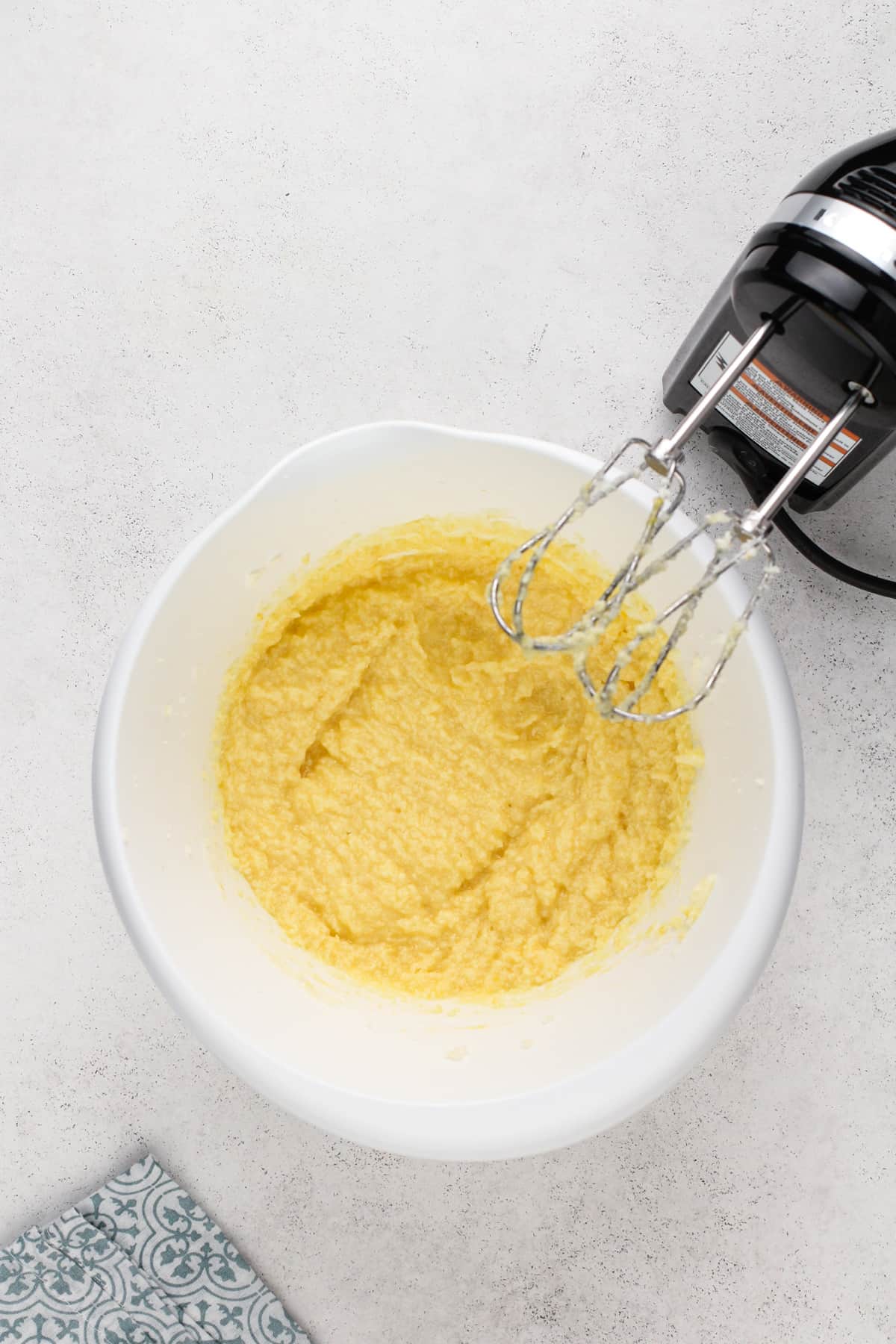 Wet ingredients for pound cake cookies mixed in a white mixing bowl.