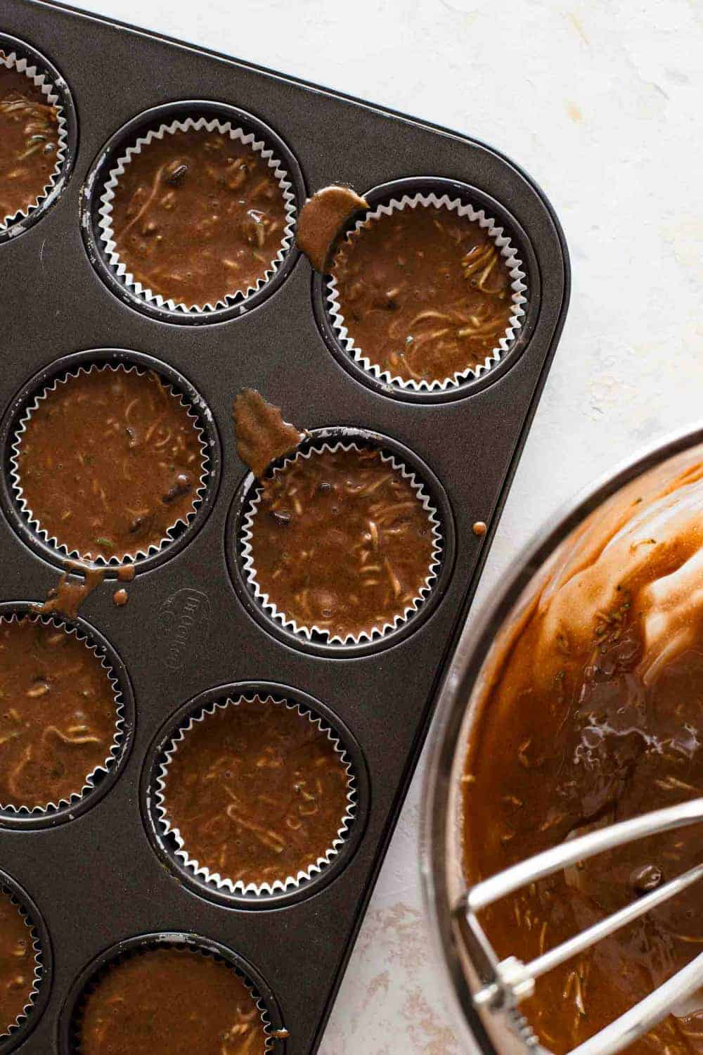 Chocolate zucchini muffin batter in a muffin pan