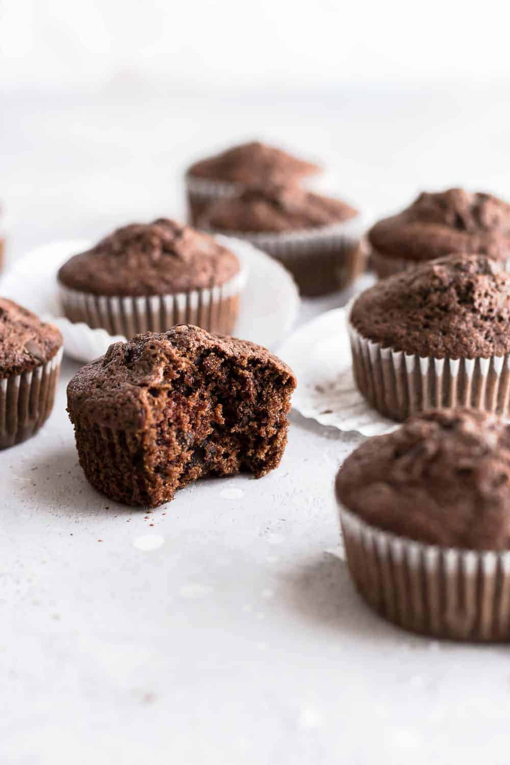 Side view of chocolate zucchini muffin with a bite taken out of it