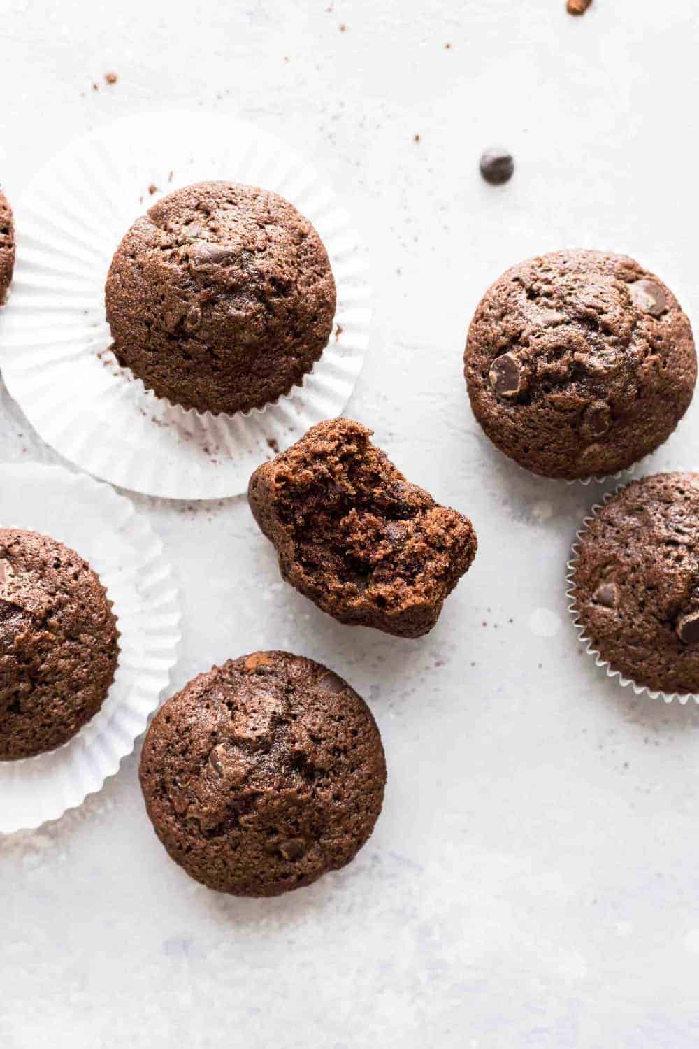 Baked chocolate zucchini muffins on a white surface