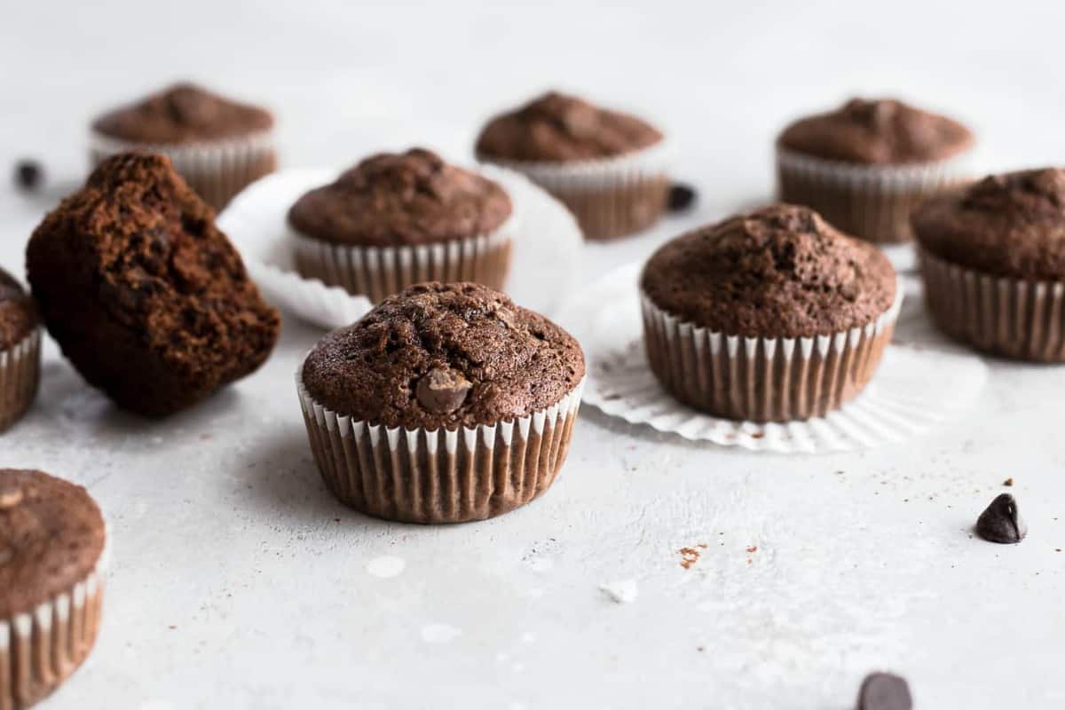 Chocolate zucchini muffins on a white surface