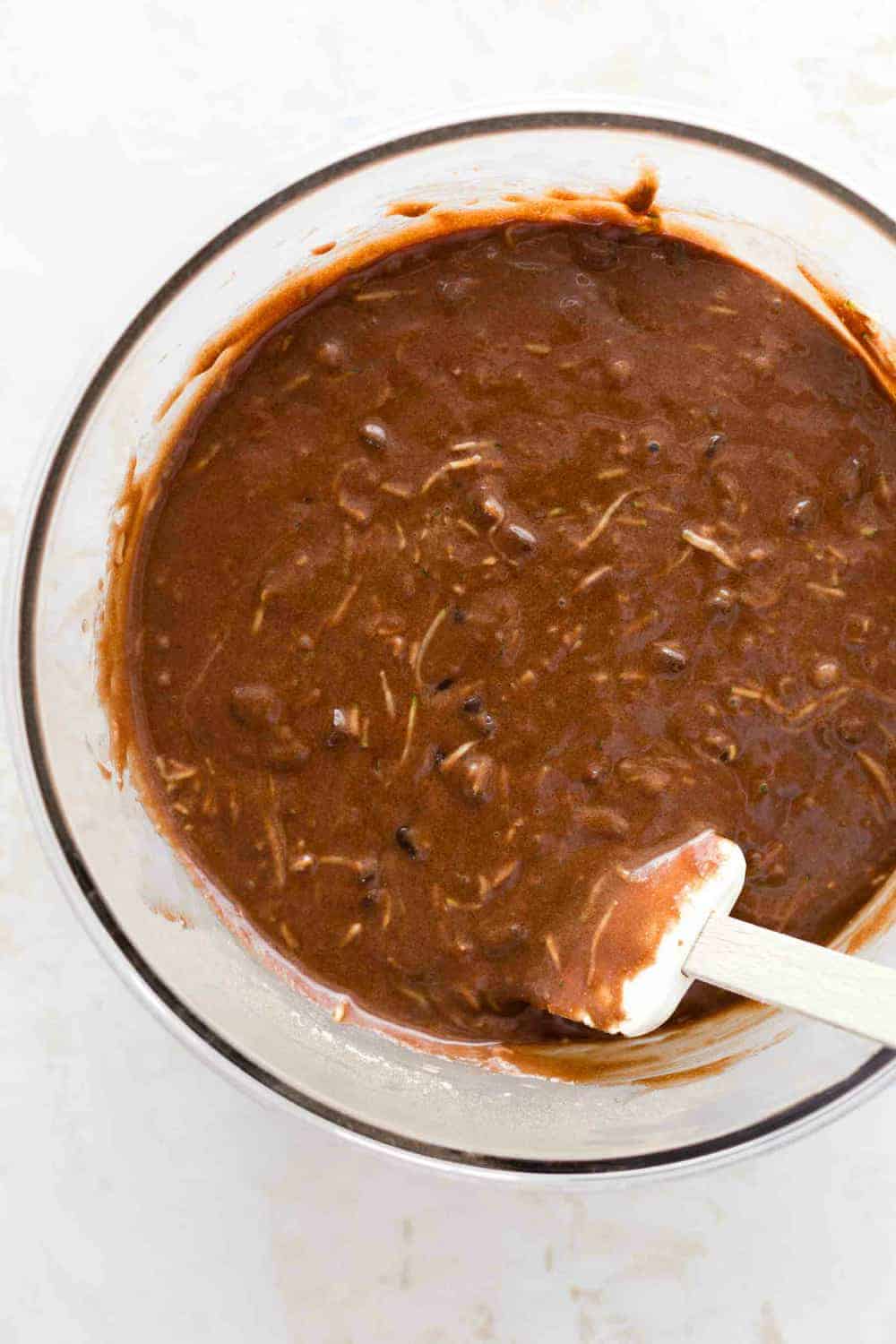 Chocolate zucchini muffin batter in a glass bowl