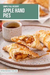 Two apple hand pies on a plate. One of them is cut in half and drizzled with caramel sauce. Text overlay includes recipe name.