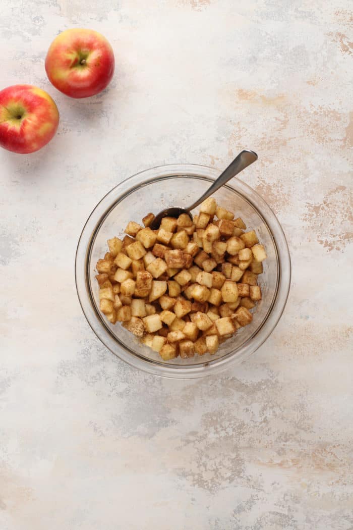 Apple hand pie filling in a glass mixing bowl.