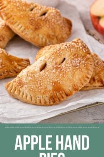 Baked apple hand pies scattered on parchment paper. Text overlay includes recipe name.