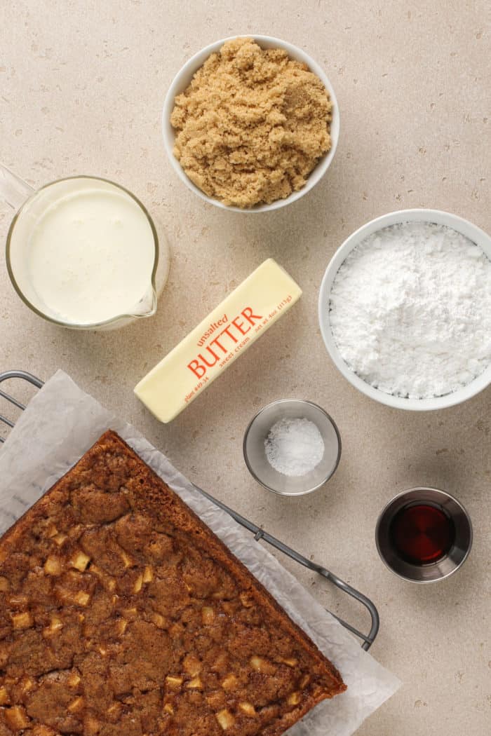 Baked caramel apple cake set next to the ingredients for salted caramel frosting.