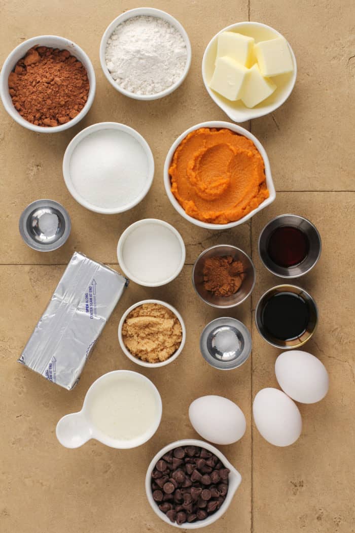 Mini pumpkin cheesecake ingredients arranged on a brown countertop.