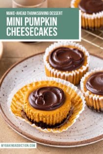 Three mini pumpkin cheesecakes on a speckled plate. The front cheesecake is unwrapped. All of them are topped with chocolate ganache. Text overlay includes recipe name.