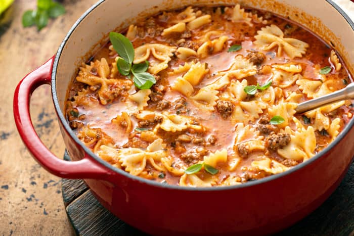 Large red dutch oven filled with lasagna soup