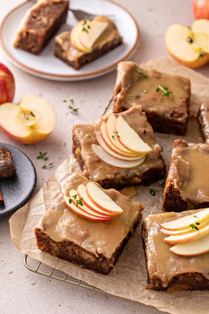 Slices of caramel apple cake arranged on a piece of parchment paper.