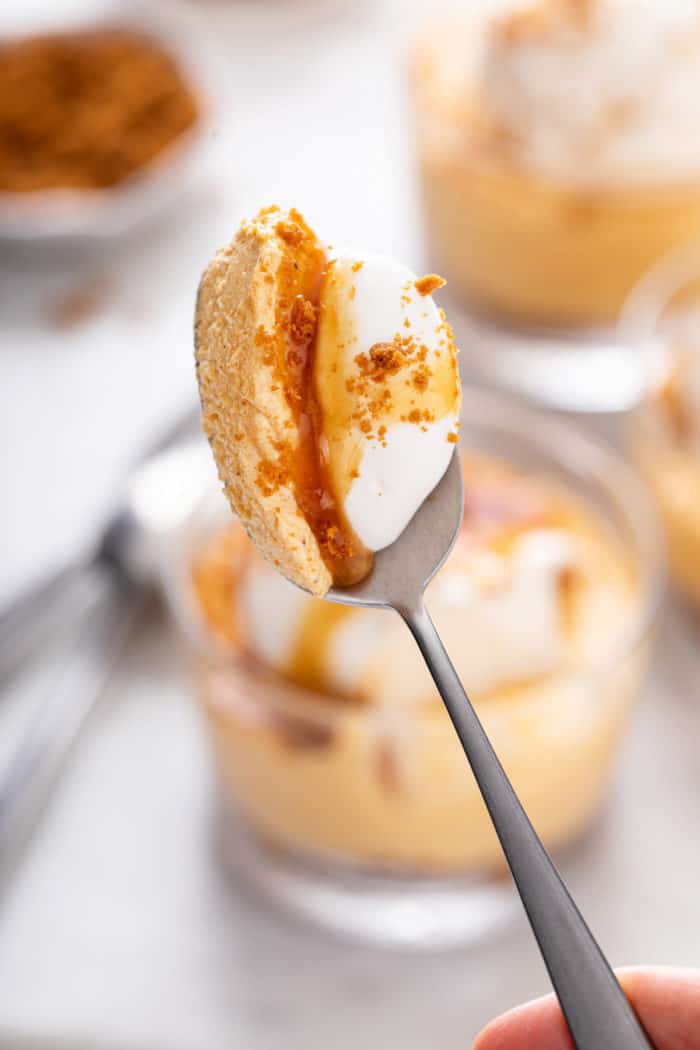Spoon holding up a bite of no-bake pumpkin cheesecake.